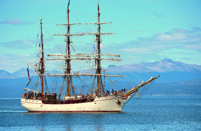white and brown ship on sea under blue sky during daytime